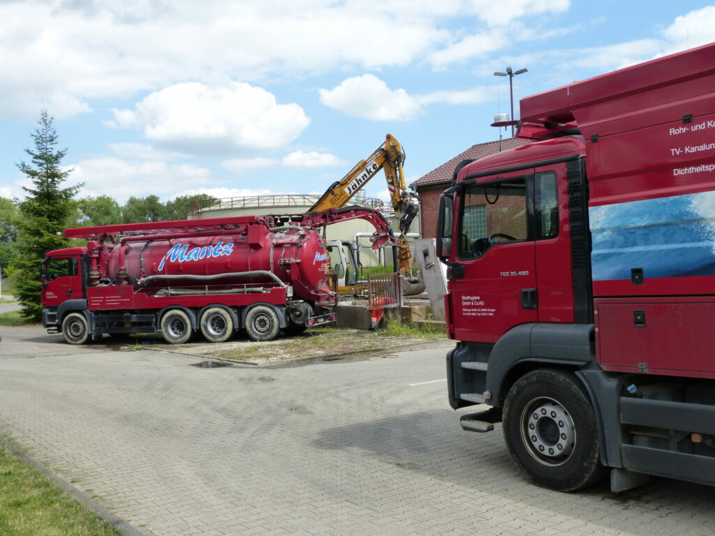 Rote Tankwagen bei Abwasserarbeiten.