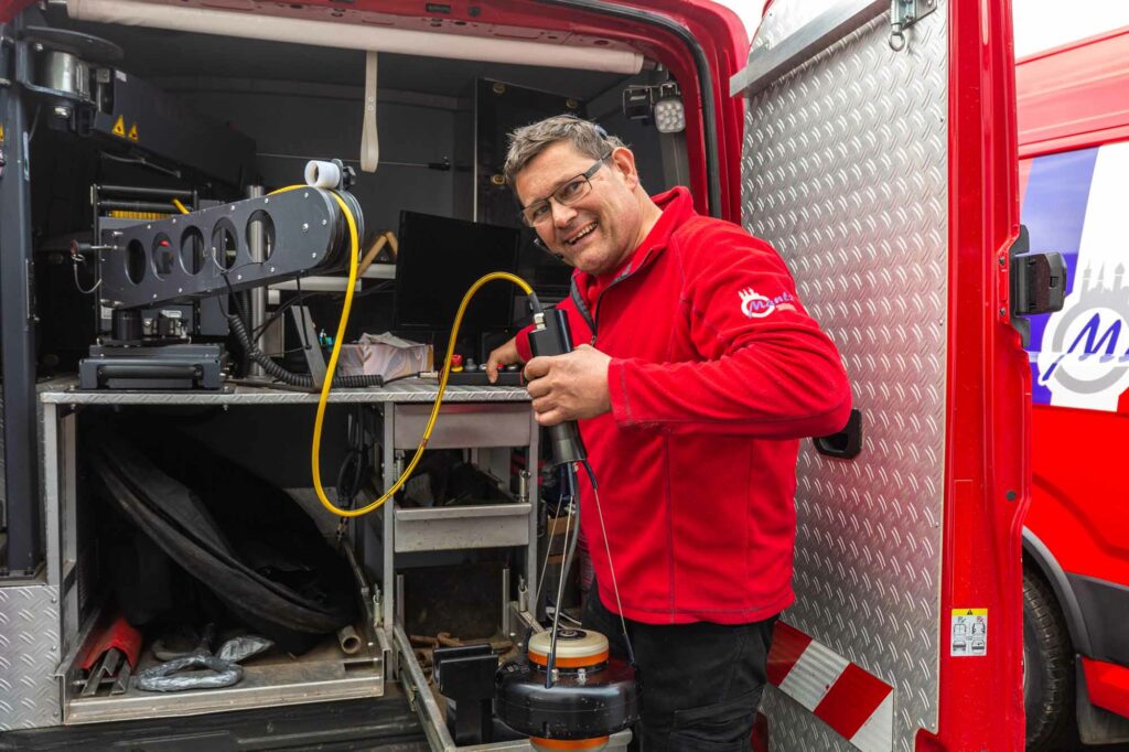 Techniker arbeitet im roten Einsatzfahrzeug.
