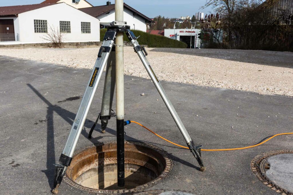 Stativ über offenem Kanalschacht montiert.