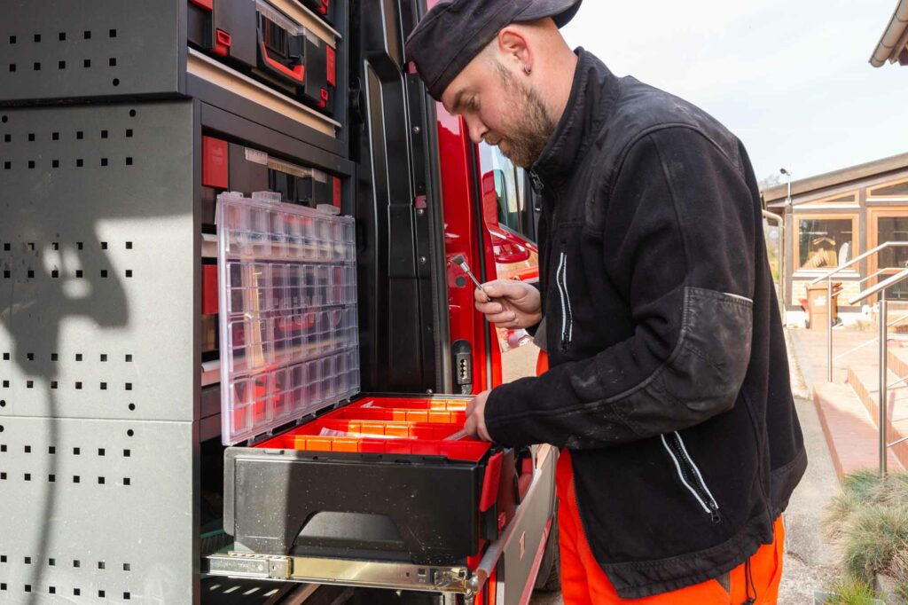 Werkzeugschublade sortieren, konzentrierter Handwerker.