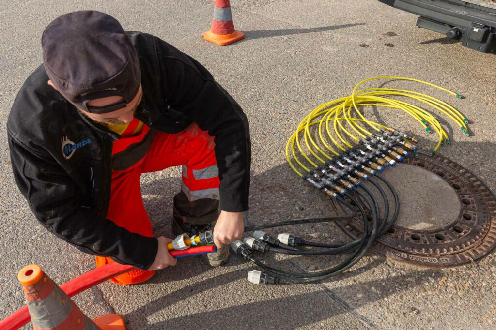 Arbeiter verbindet bunte Glasfaserkabel.