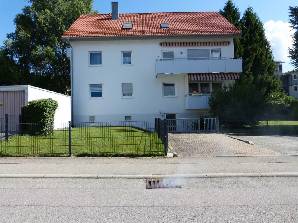 Rauch steigt aus Gullydeckel.