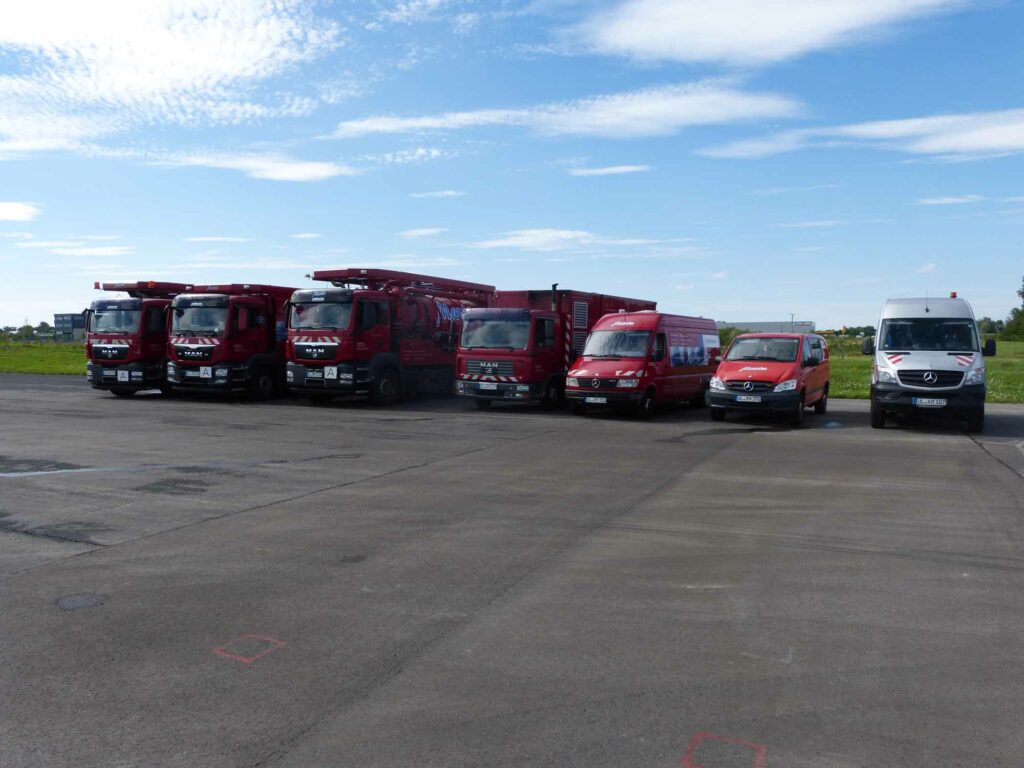 Rote Einsatzfahrzeuge auf weiter Fläche.